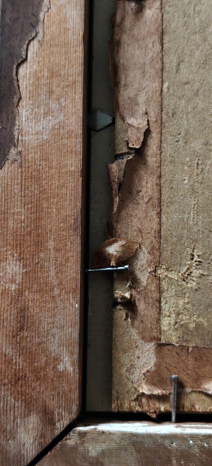 6-E. De Jager — details van de gelaagde achterafsluiting. Onder/achter gescheurde papieren stroken zijn metalen driehoekige/puntvormige vergrendelelementen zichtbaar naast de huidige spijkerbevestiging. De oorspronkelijk