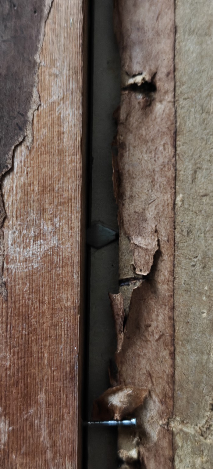 6-E. De Jager — details van de gelaagde achterafsluiting. Onder/achter gescheurde papieren stroken zijn metalen driehoekige/puntvormige vergrendelelementen zichtbaar naast de huidige spijkerbevestiging. De oorspronkelijk